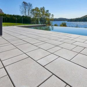 Poolside patio with modern tiles and scenic lake view.