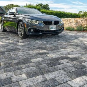 Car parked on cobblestone driveway for website renaming project.