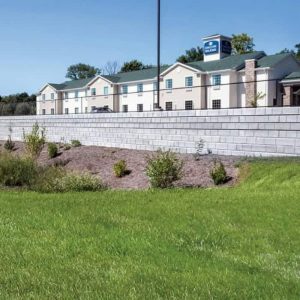 Modern apartment complex with landscaped yard and new wall.