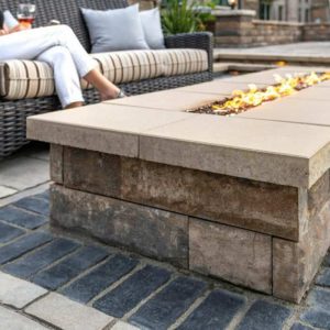 Modern outdoor fire pit with stone base and seating area.