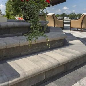 Outdoor stone staircase with plants and seating area.