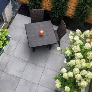 Outdoor patio furniture set with table and chairs in garden setting.