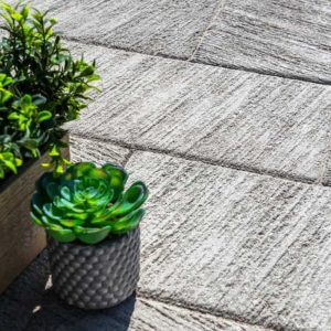 Outdoor stone patio featuring potted succulents and lush greenery for a stylish garden space.