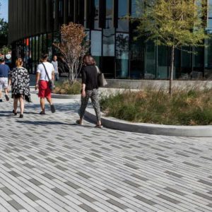 Urban sidewalk with pedestrians in front of a modern office building.
