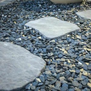 Stone pathway with large flat stones and small gravel for landscaping.