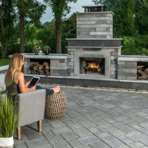 Outdoor fireplace with seating and firewood storage for cozy outdoor gatherings.