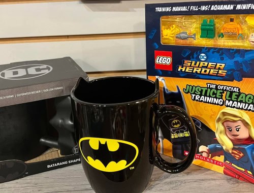 Black Batman mug with yellow logo and LEGO Super Heroes Justice League manual.