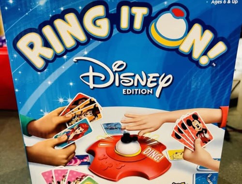 Children playing Disney themed card game with a red ring toss device.