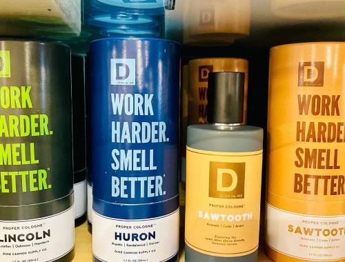 Assorted bottles of work cologne with bold labels and vibrant colors.