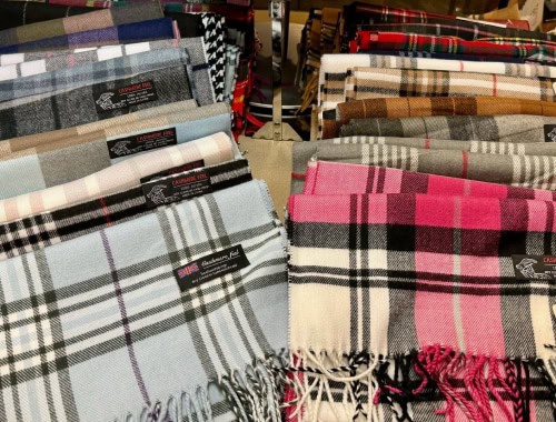Variety of plaid and checkered scarves in different colors on display.