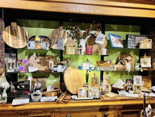 Display of various gift items including mugs, wooden decor, and framed art at Molehole of Marshall.