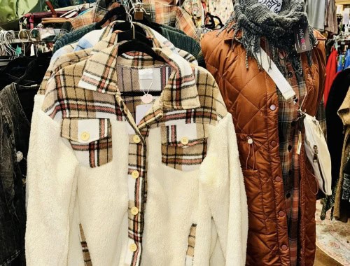 Cozy plaid and quilted jackets displayed at Molehole thrift store.