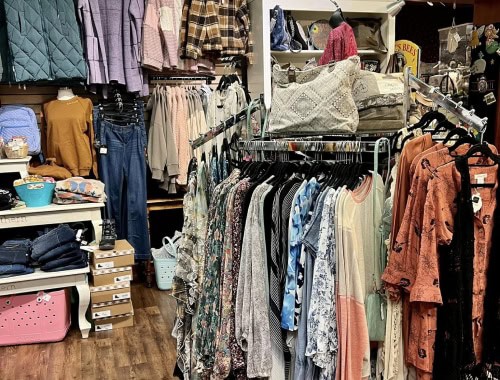 Clothing racks with casual and formal wear in a retail store.
