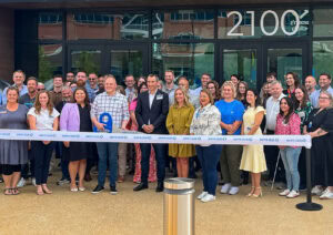 Bentonville Mayor Stephanie Orman and A group of people stand behind a ribbon at a ribbon cutting event for Sam's clubhouse in Bentonville, Arkansas