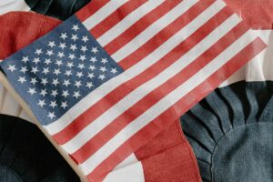 An American flag on a fabric background with red, white, and blue patterns.