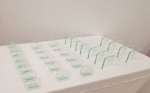 Rows of neatly arranged transparent chairs on a white surface, possibly in preparation for an event or a display.