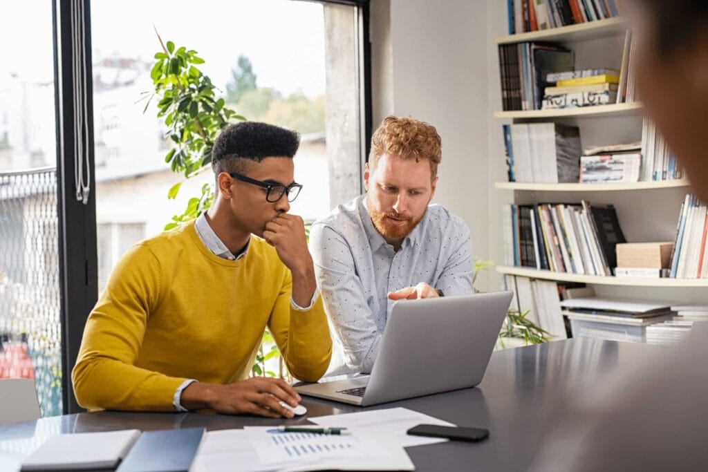 Two people working on a laptop
