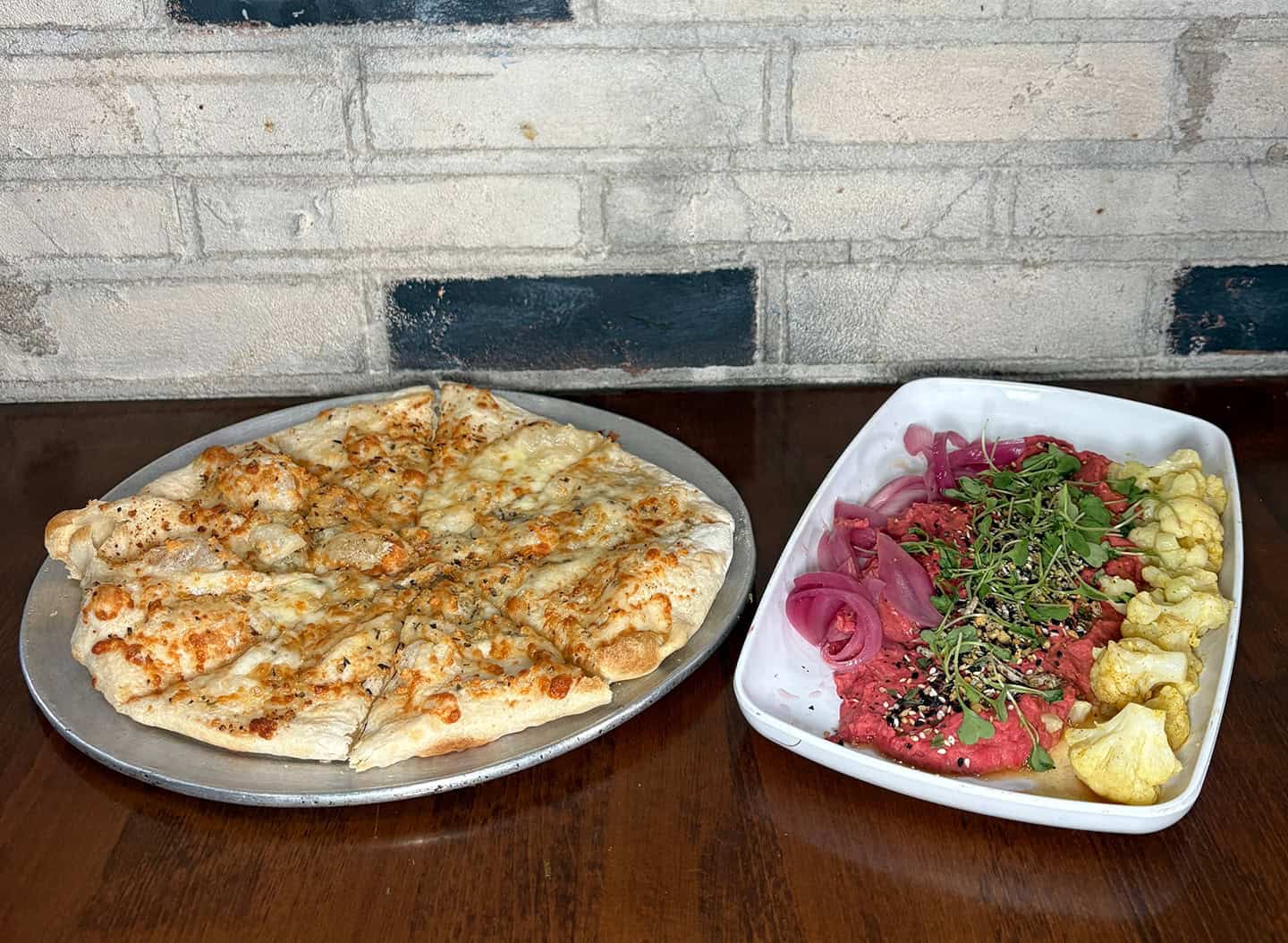 Cheese pizza with salad on a wooden table at Pints & Quarts.