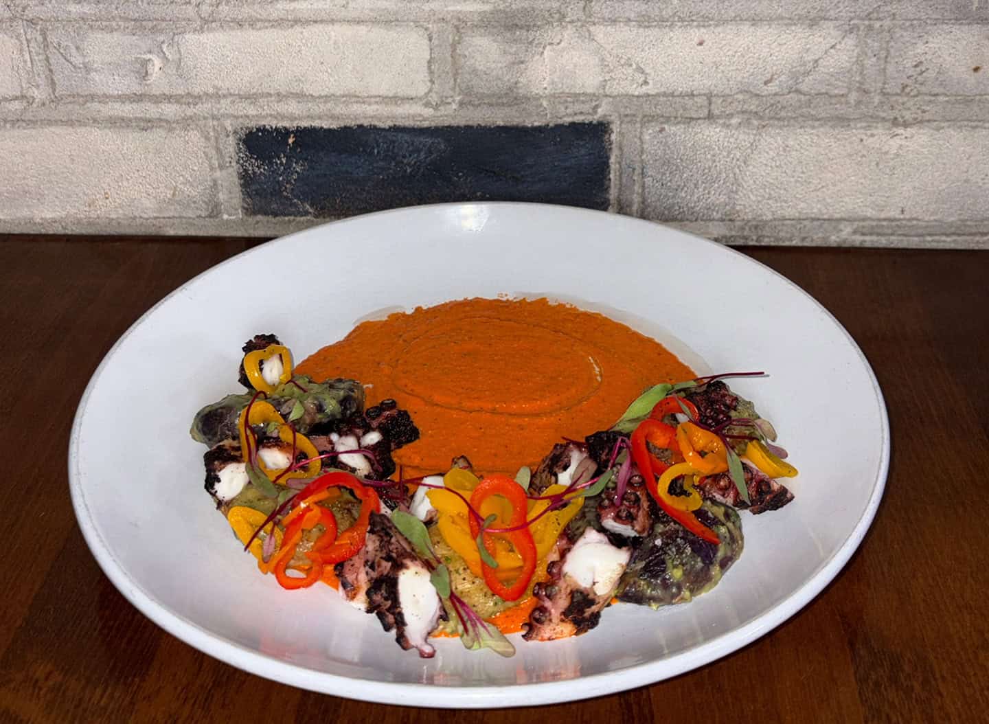 Vibrant plated dish with orange sauce and fresh vegetables.