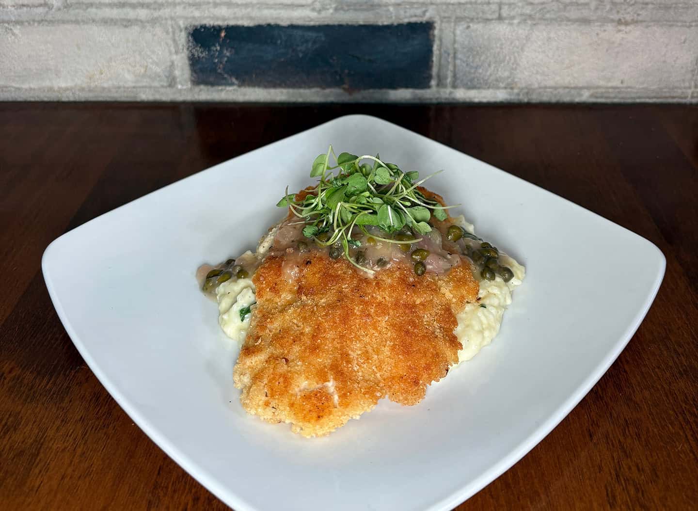 Golden crispy fish fillet served with microgreens and creamy mashed potatoes.