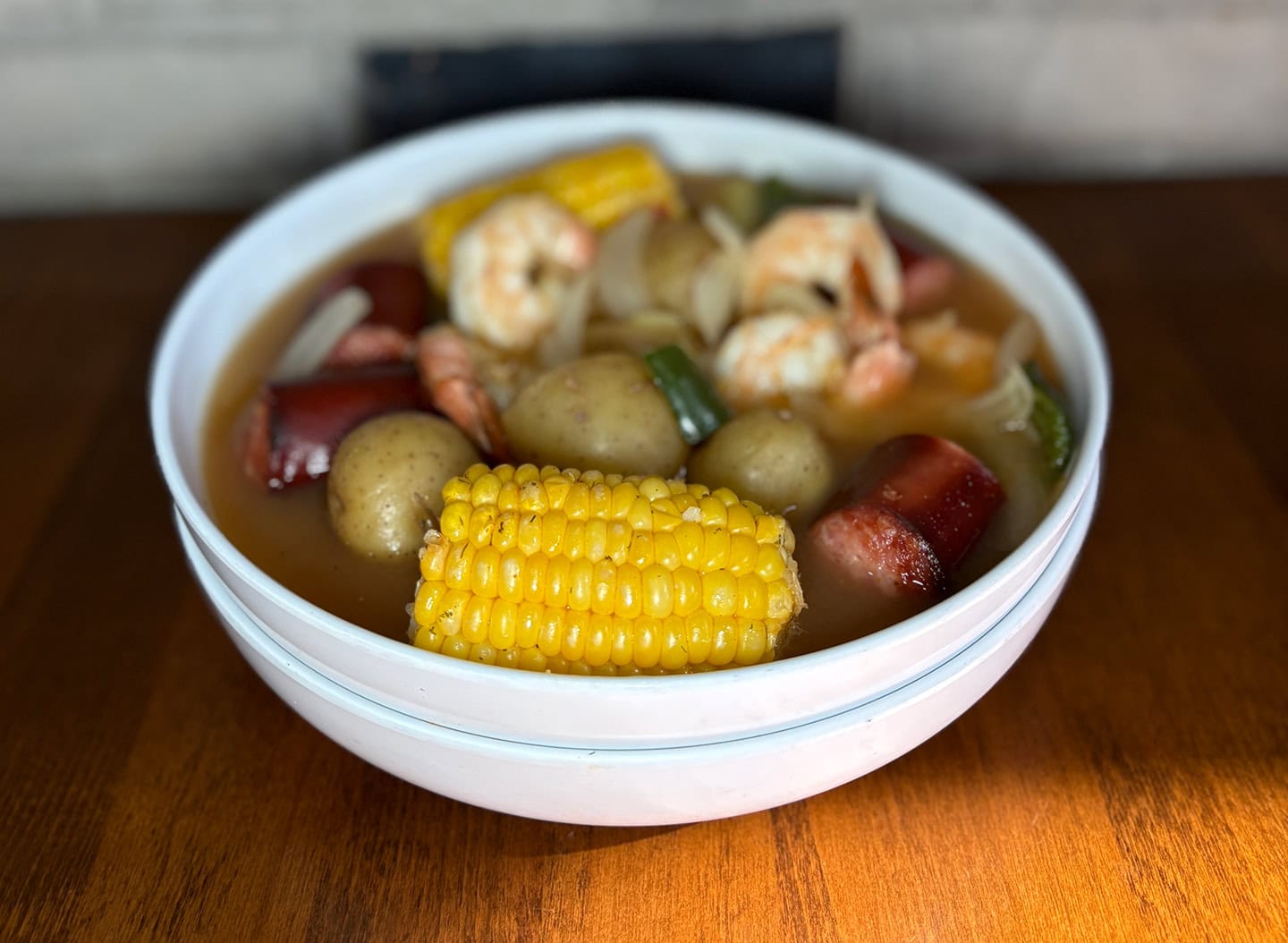Seafood boil with shrimp, sausage, corn, and potatoes in a bowl.