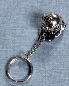 20240410_095814 Un porte-clés en forme de casque de plongée vintage évoque l'aventure sous-marine et l'exploration des fonds marins.