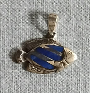 Un pendentif en forme de poisson aux nuances bleues évoque l'élégance des récifs coralliens, symbole parfait pour les pass...