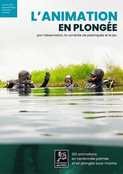 Plongeurs en combinaison discutent à la surface d'un lac, illustrant l'importance de l'animation en plongée pour l'explora...