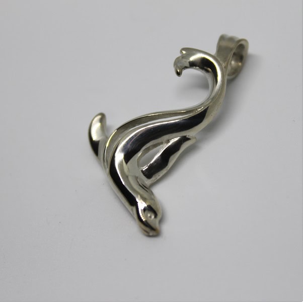 Ce pendentif argenté en forme de lion de mer évoque l'élégance et la liberté des créatures marines.