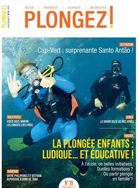 Deux plongeurs explorent les profondeurs marines, illustrant l'aventure éducative de la plongée pour enfants.