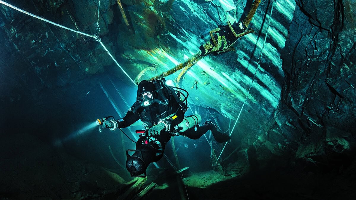 Un plongeur technique explore une mystérieuse grotte sous-marine, illuminant les secrets cachés des profondeurs. #Exploration