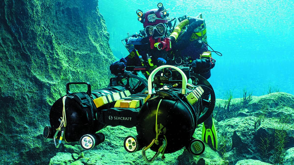 Un plongeur tek explore les profondeurs avec un scooter sous-marin, illustrant l'aventure ultime en exploration marine.