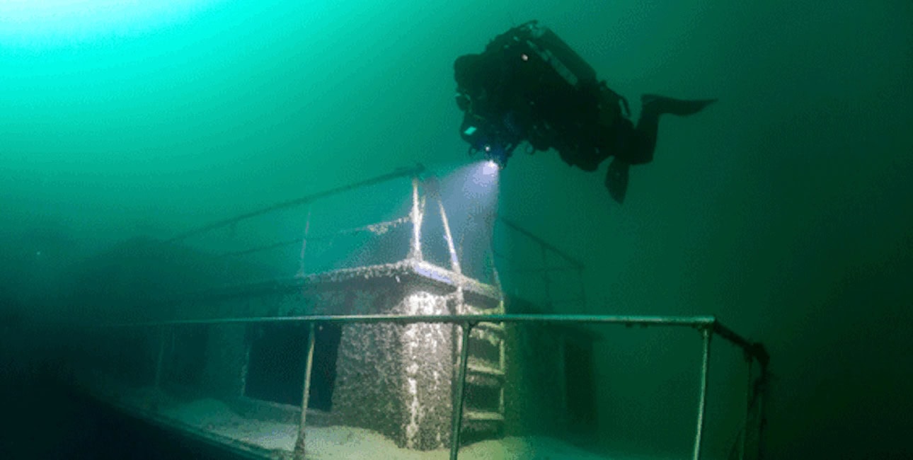 Un plongeur explore l'épave mystérieuse d'un navire englouti, éclairant les secrets de l'océan. #ExplorationSousMarine
