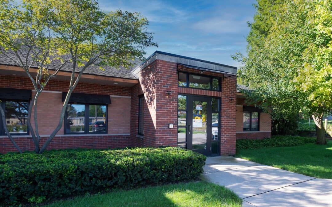 Contemporary brick medical office with glass entrance and surrounding greenery.