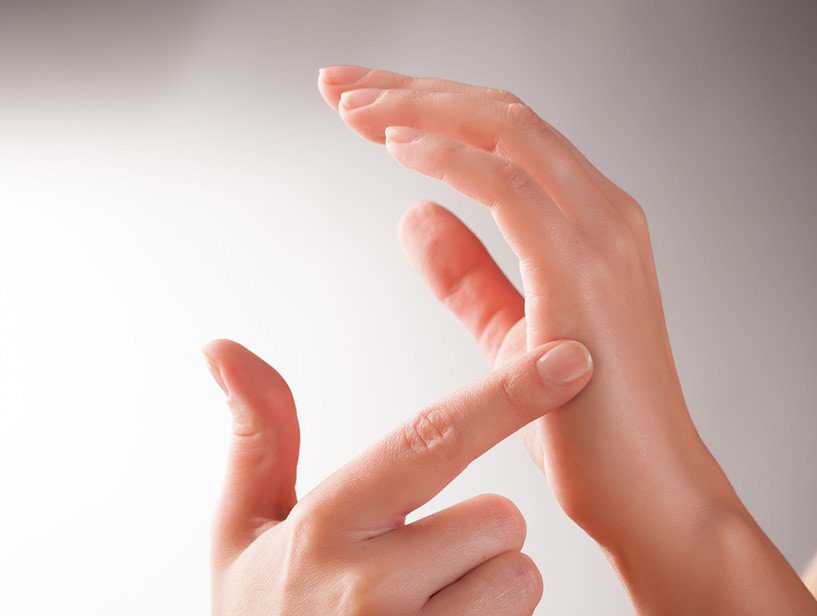 Close-up of hands demonstrating skin care or massage technique.