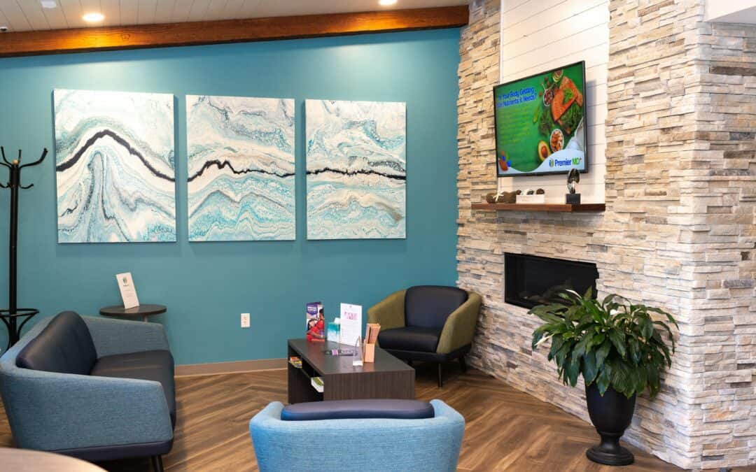 Comfortable waiting room with abstract wall art and a TV at PremierMD+.