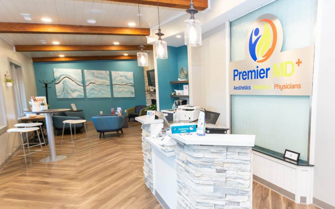 Modern medical office reception with PremierMD+ sign and comfortable seating.