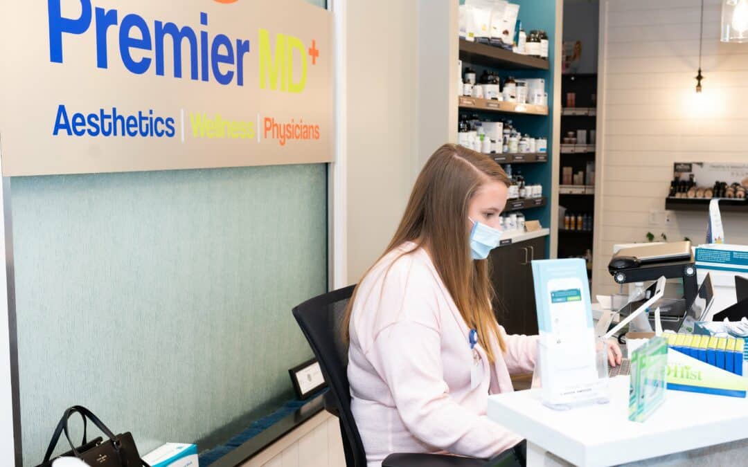 Reception area at PremierMD+ with staff and skincare products.