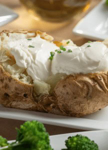 Buttered baked potato topped with sour cream and chives.