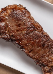 Juicy, perfectly cooked steak on white plate at Prime Steakhouse.