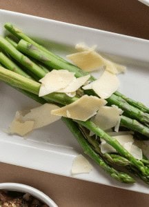 Fresh asparagus with shaved cheese on a white plate at Prime Steakhouse.