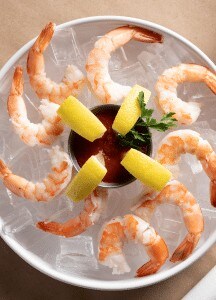 Succulent shrimp cocktail with lemon wedges and fresh herbs for a seafood appetizer.