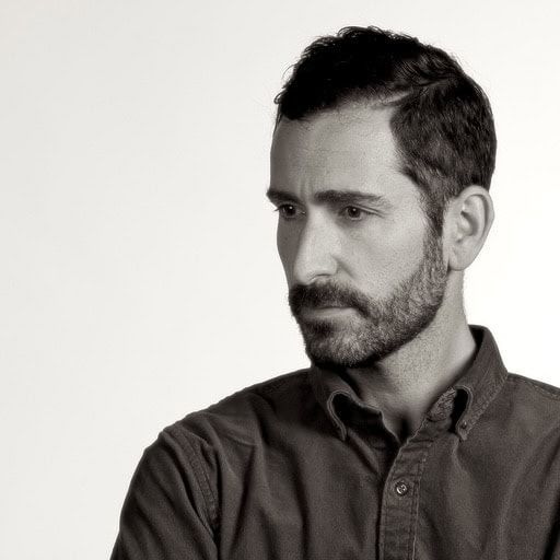 Black and white portrait of a man with short dark hair and beard.