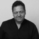 Black and white portrait of David D. in a black shirt.