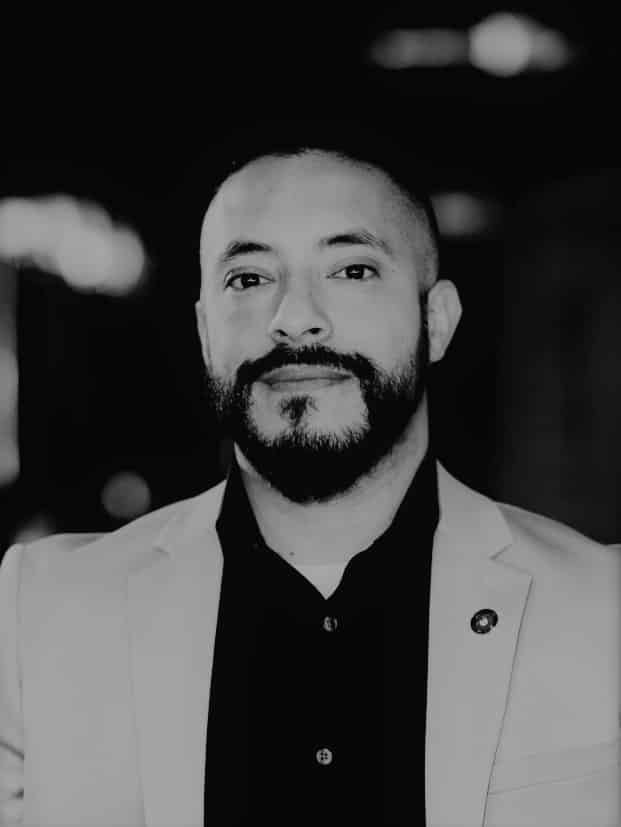 Black and white portrait of Alvaro P. with beard and suit.