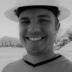 Smiling construction worker wearing safety helmet outdoors.