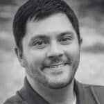 Close-up of a smiling man with short dark hair and beard.