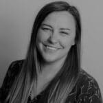 Portrait of Brittany A. smiling, professional headshot in black and white.