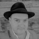 Black and white portrait of a man wearing a hat and suit.