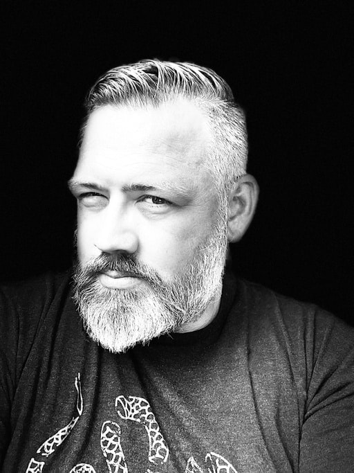 Black and white portrait of a man with a beard and short hair.